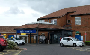 Image shows photo of the outside of the North Tyneside General Hospital building, showing the front entrance and main entrance signage.